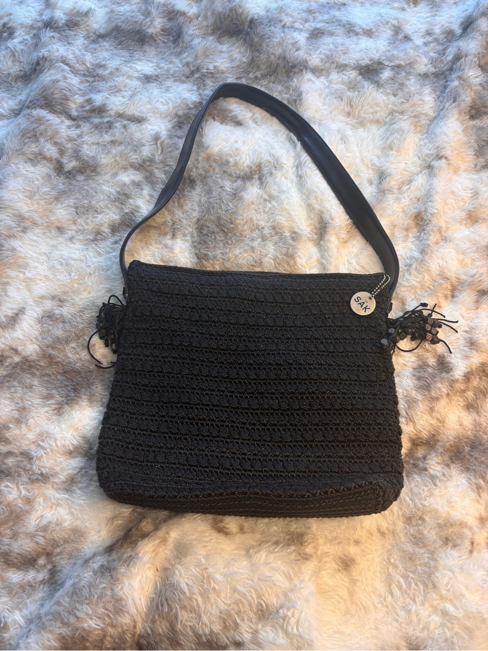The Sak Black Crochet Shoulder Bag with Tassel Charm